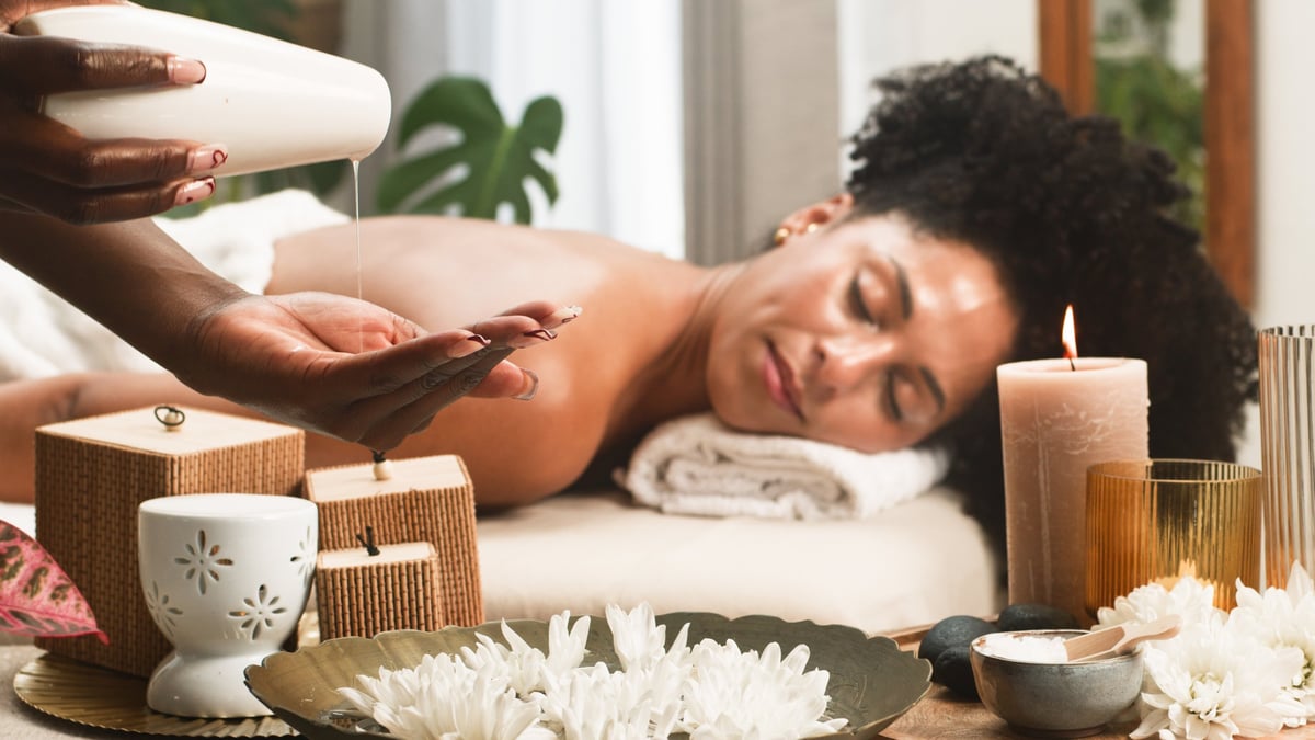 A serene treatment room with candles and flowers during a soothing massage